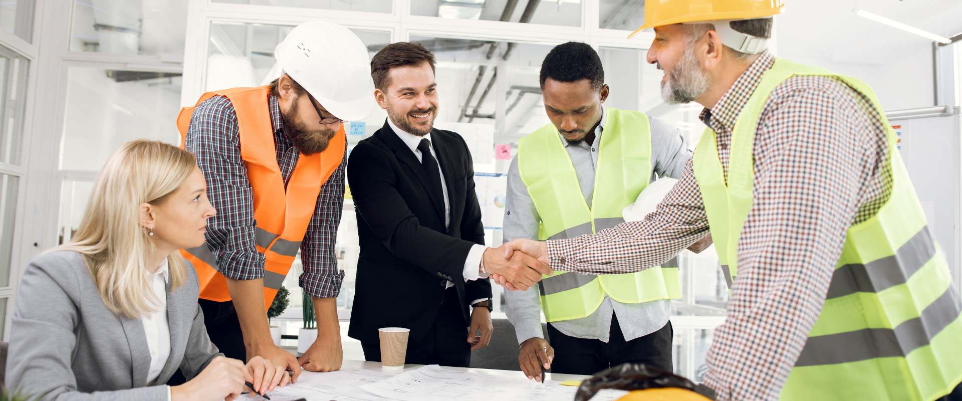 Business professional shakes hand with construction worker