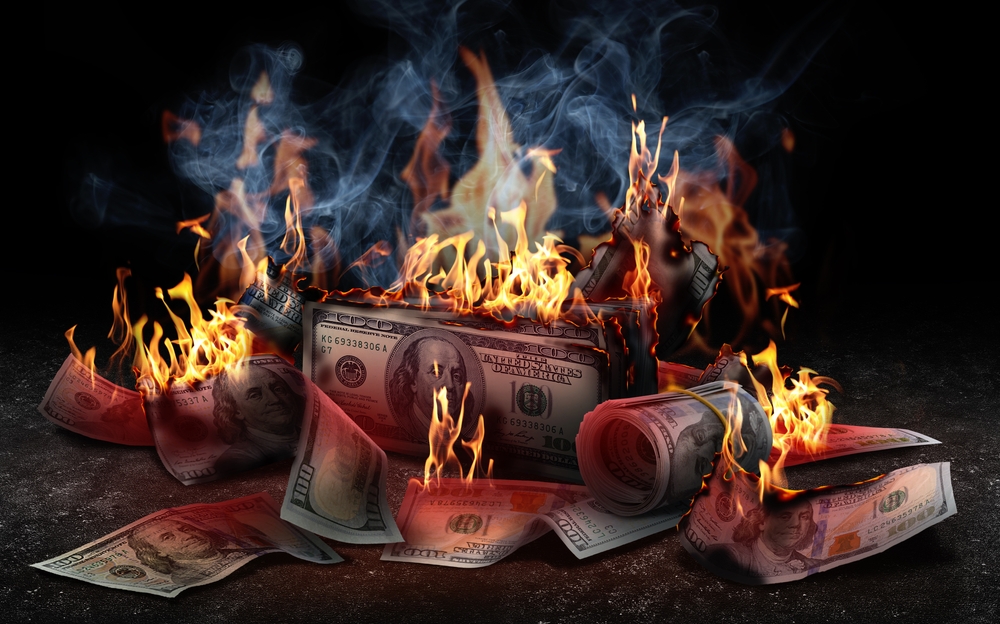 Burning,Money,On,Black,Background.,Financial,Crisis Cost of bad payroll software